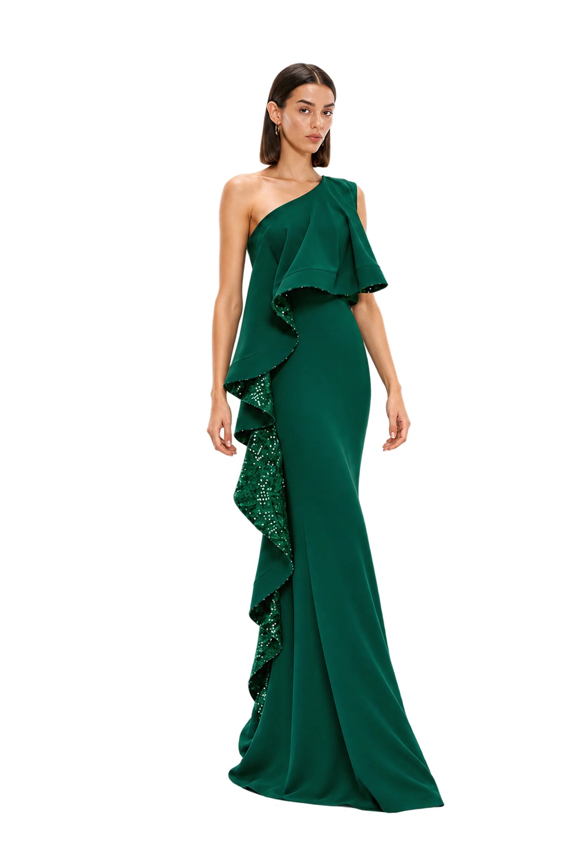 A woman modeling a floor-length one-shoulder avaro figlio forest green dress with cascading ruffles and sequined detailing on a light gray studio background.