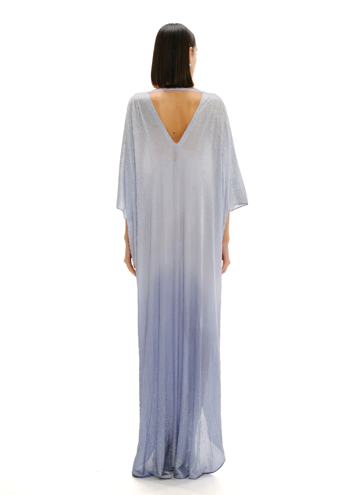 Model wearing Avaro Figlio light celestial blue maxi caftan dress with a V-neckline, draped tie detail at the bust, and flowing sheer fabric, shown on a plain white background.