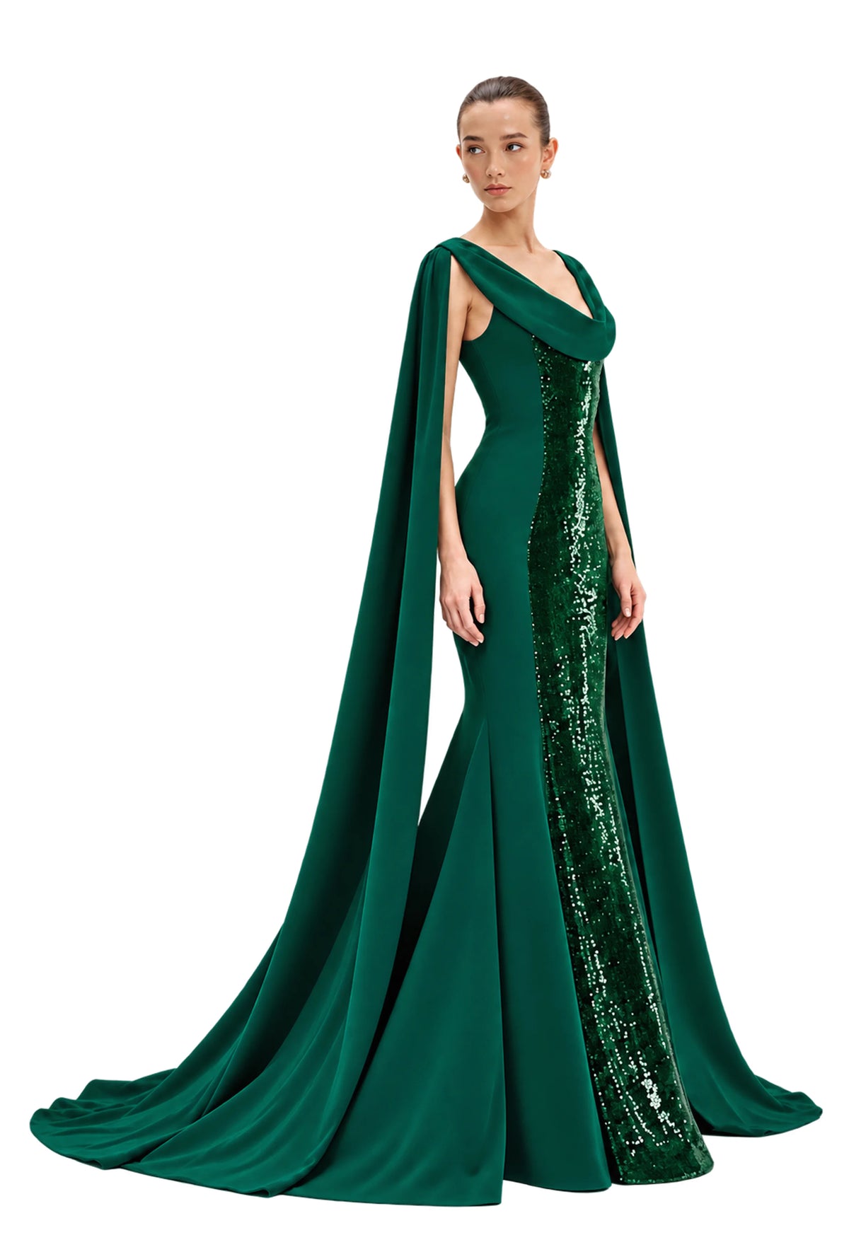 A model wears a floor-length Avaro Figlio forest green gown with a draped cape and a shimmering sequined side panel, photographed against a light gray studio background.